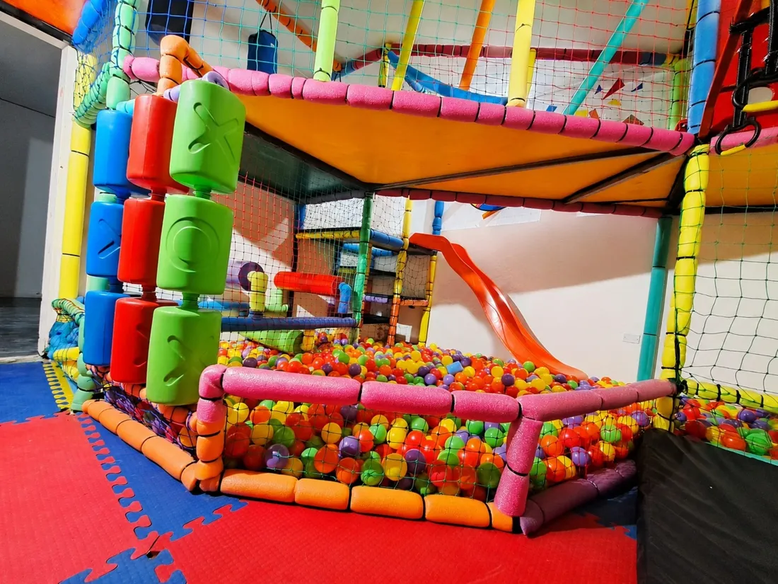 Laberinto de varios niveles con tubos de colores, tobogán naranja y piscina de pelotas