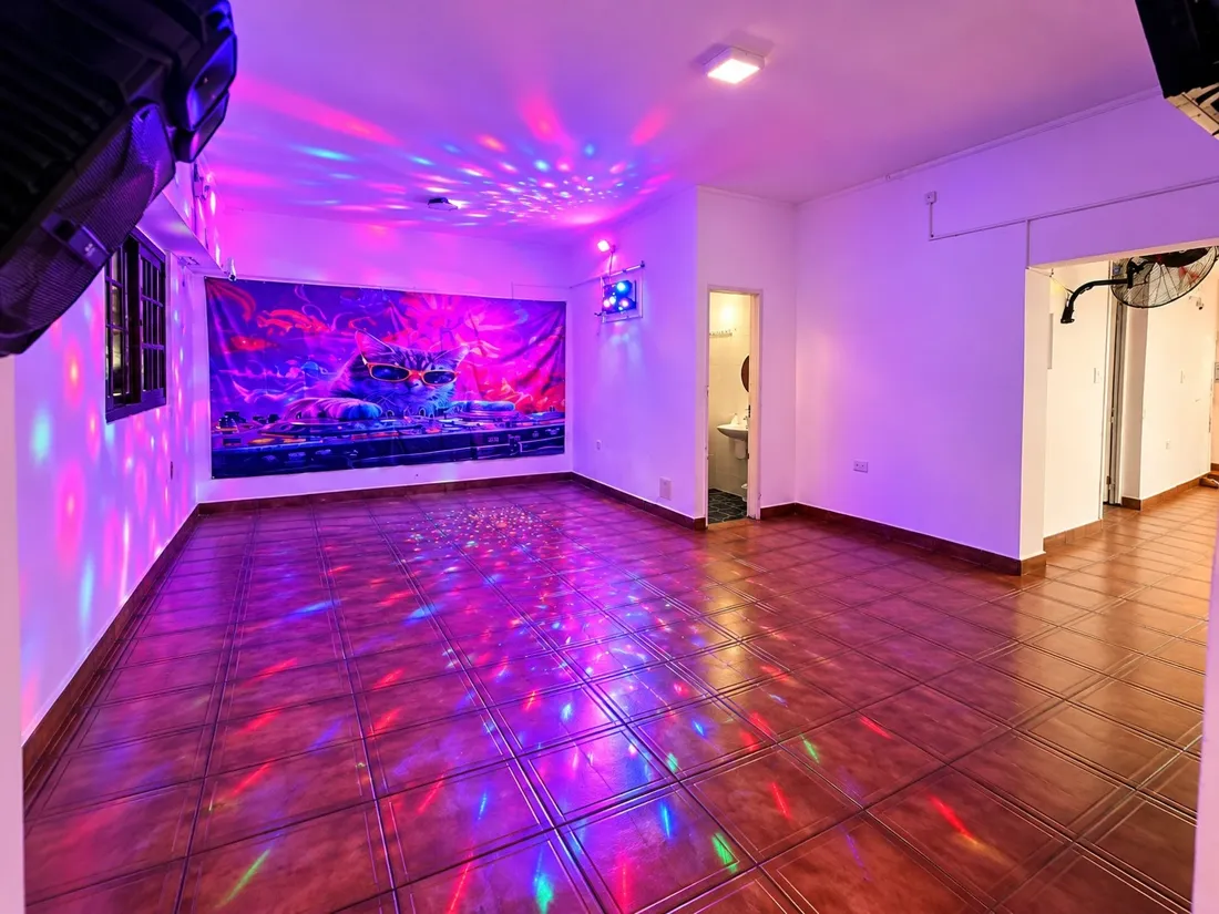 Sala de baile con luces de colores reflejadas en el piso y el techo
